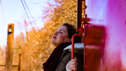 Close-up of woman standing by metallic structure