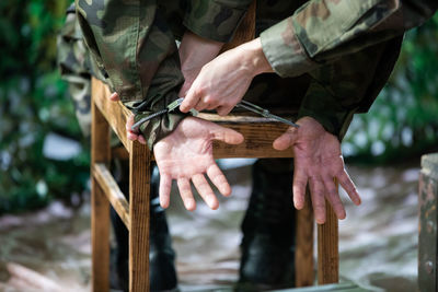 A woman puts handcuffs on a military suspect at the barracks.