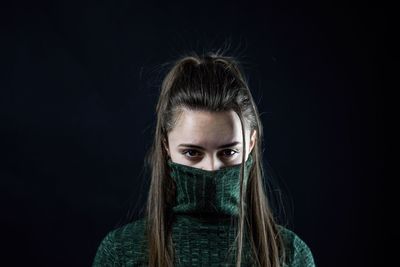 Portrait of woman against black background