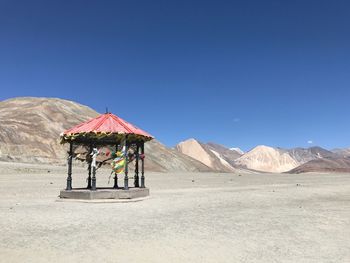 Scenic view of desert against clear blue sky