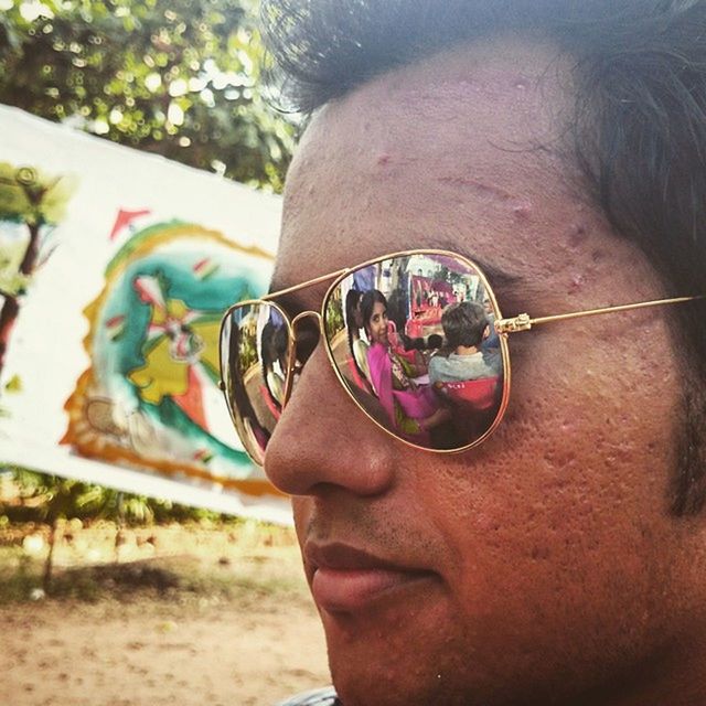 lifestyles, focus on foreground, headshot, leisure activity, sunglasses, close-up, person, human face, young adult, holding, portrait, part of, looking at camera, front view, day, head and shoulders
