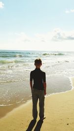 Full length of man standing on beach against sky