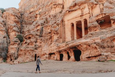 Side view of female tourist walking near ancient the treasury temple during vacation in petra