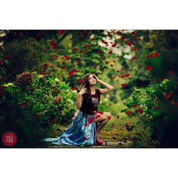 Full length portrait of young woman against plants