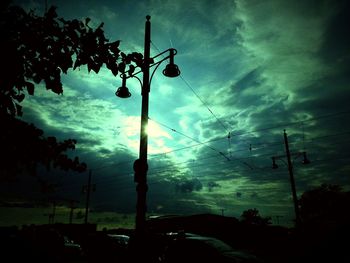Silhouette of trees against cloudy sky