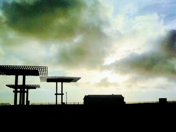 Low angle view of silhouette windmill against sky