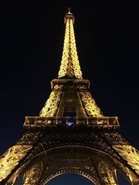 Low angle view of illuminated tower against sky at night