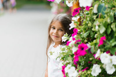 Cute girl is resting in the park in the summer among the flowers on summer vacation