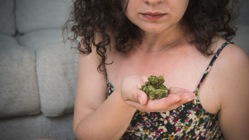 Midsection of woman holding marijuana