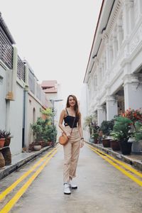 Portrait of young woman standing in city