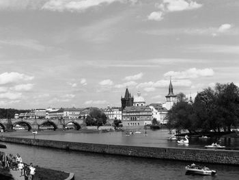 Charles bridge over vltava river in city against sky