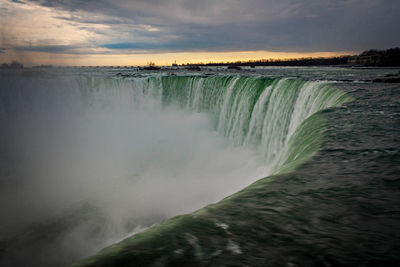 Scenic view of waterfall against sky