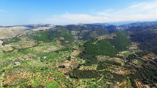 Aerial view of landscape and mountains against blue sky