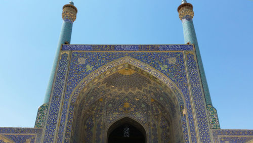 Low angle view of mosque against clear blue sky