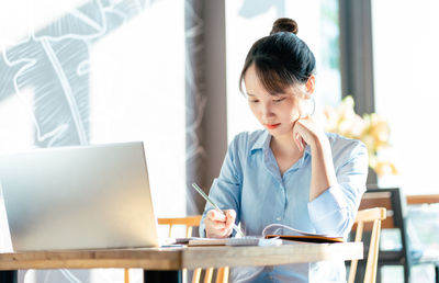 Young woman using laptop at home