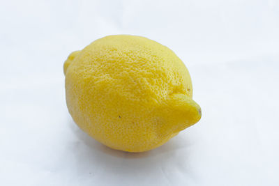 Close-up of yellow fruit against white background