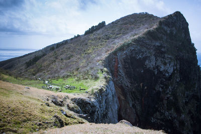 Scenic view of rock formation by sea against sky