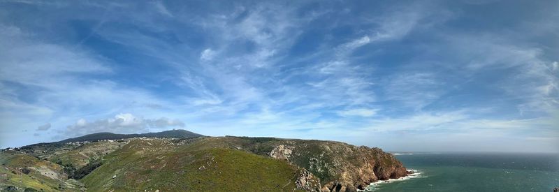 Scenic view of sea and mountains against sky