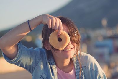 Close-up portrait of smiling young woman standing outdoors