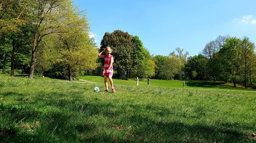 Full length of girl playing soccer at park