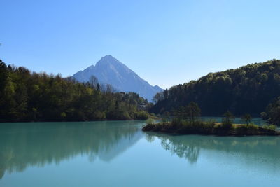 Scenic view of lake and mountains against clear sky