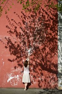 Rear view of woman standing by tree