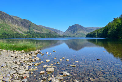 Scenic view of lake against clear blue sky