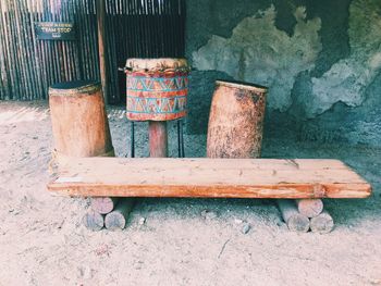 Close-up of old wooden bench against wall