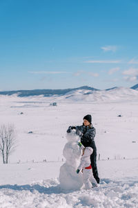 Rear view of woman standing on snow covered landscape