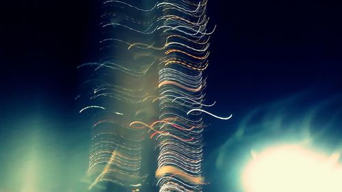 Low angle view of light trails against sky at night