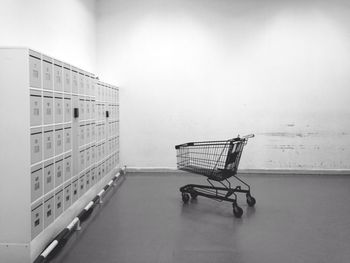 Shopping cart by lockers on floor in room