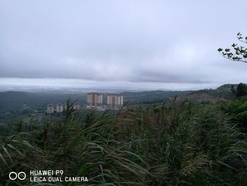 Scenic view of city by sea against sky