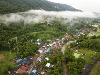 Aerial view of a village in the lush green rain cloud cover tropical rain forest mountain