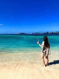 Woman on beach against clear blue sky