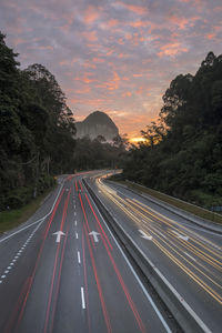 Road leading towards mountain against sky