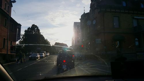 Cars on street in city against sky