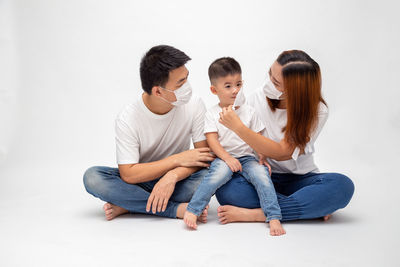 Friends sitting against white background