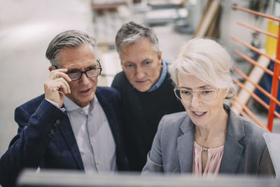 High angle view of businesswoman with colleagues in meeting at industry