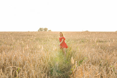 Woman standing on field against clear sky