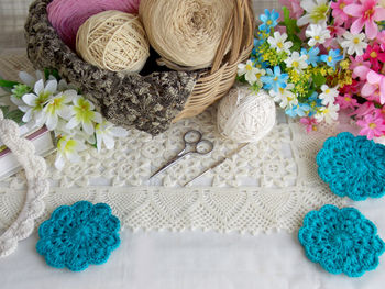 High angle view of artificial flowers with wool on table