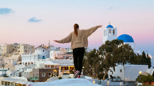 Woman by temple against sky