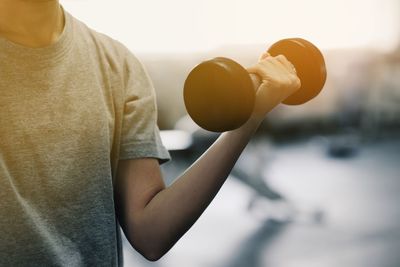 Midsection of woman holding ball