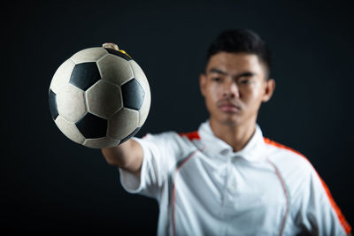 Portrait of young man with ball in background