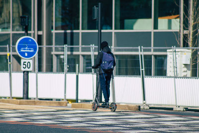 Rear view of man walking on road