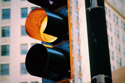 Close-up of illuminated stoplight against buildings