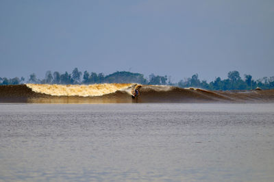 Man in water against clear sky