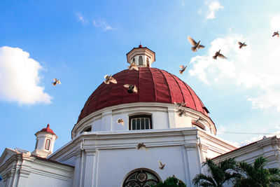 Low angle view of bell tower amidst buildings against sky