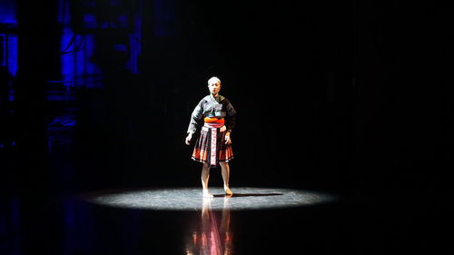 Rear view of woman walking on street at night