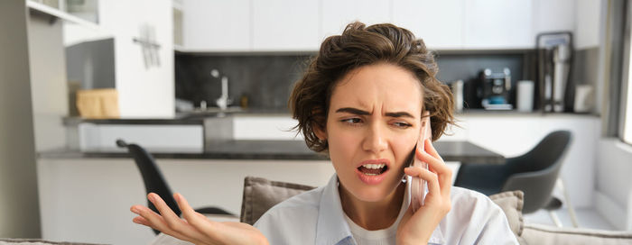 Young woman using mobile phone at home