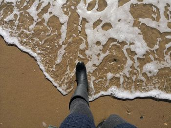 Low section of person standing on beach